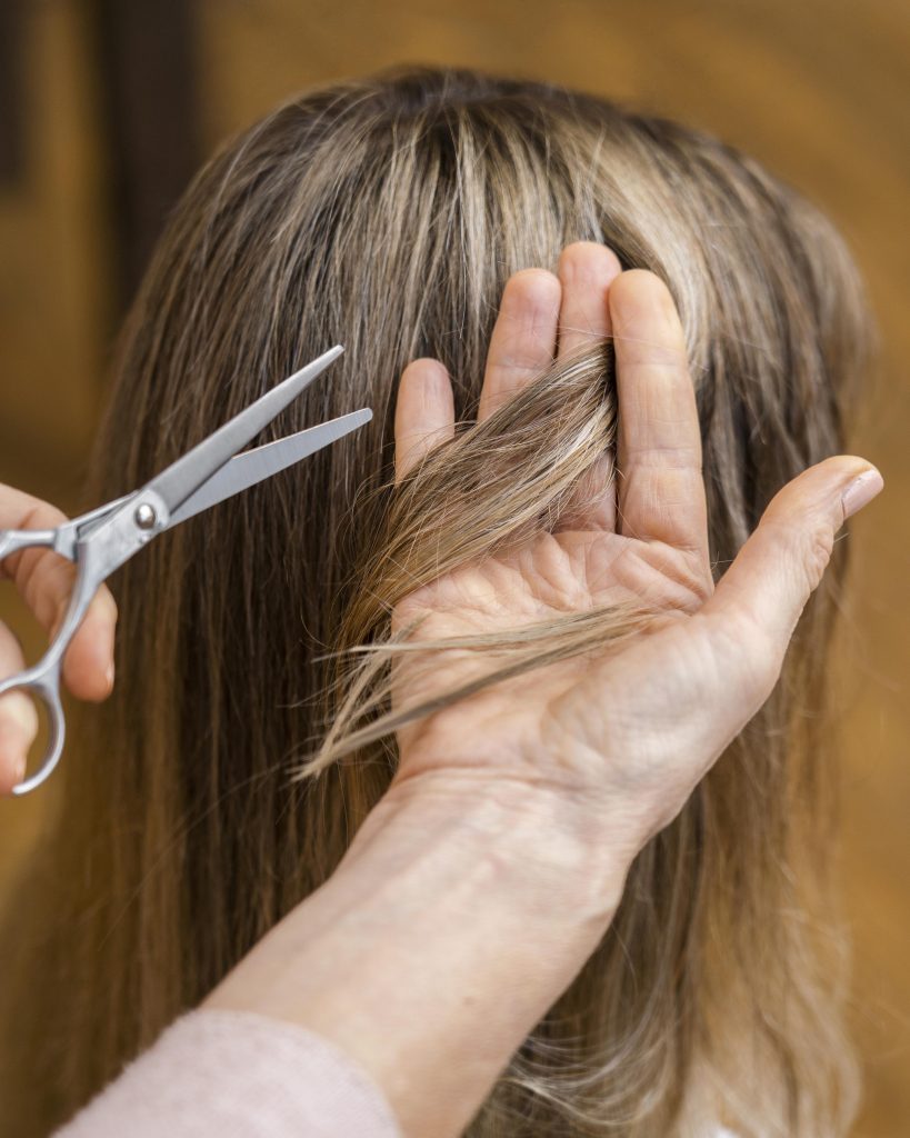 Woman getting haircut home by beautician