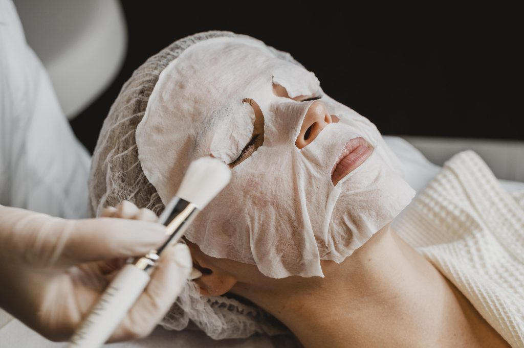 Woman getting skin mask treatment wellness center